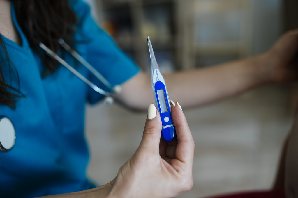 Nurse checking a patient's temperature