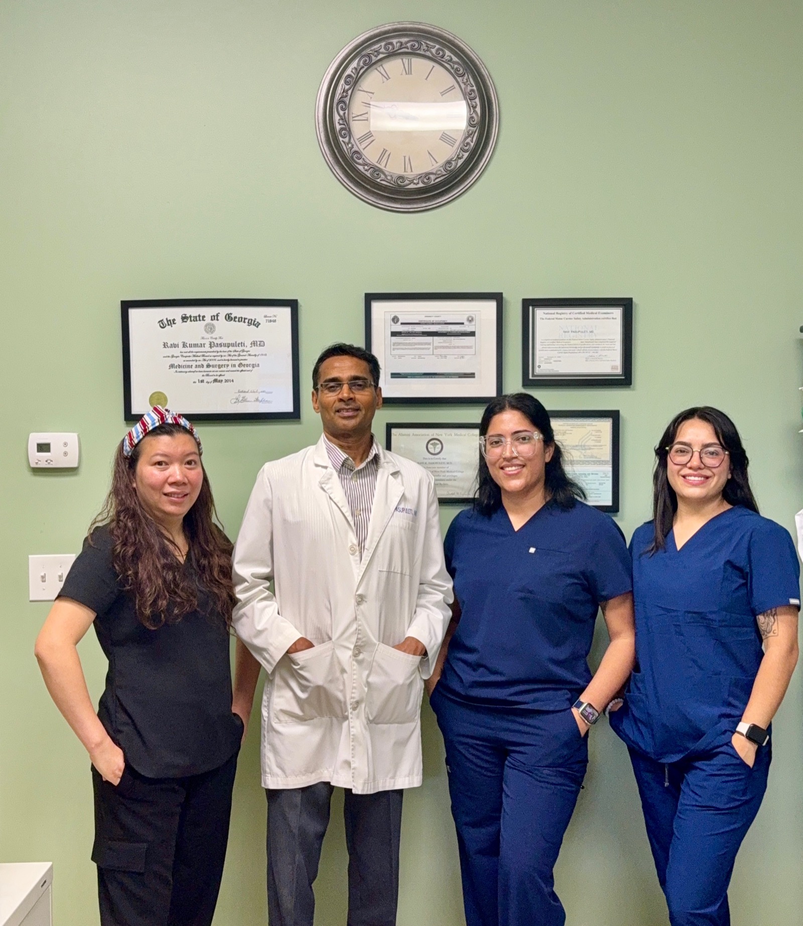 Trinity Family Clinic team by the credentials wall